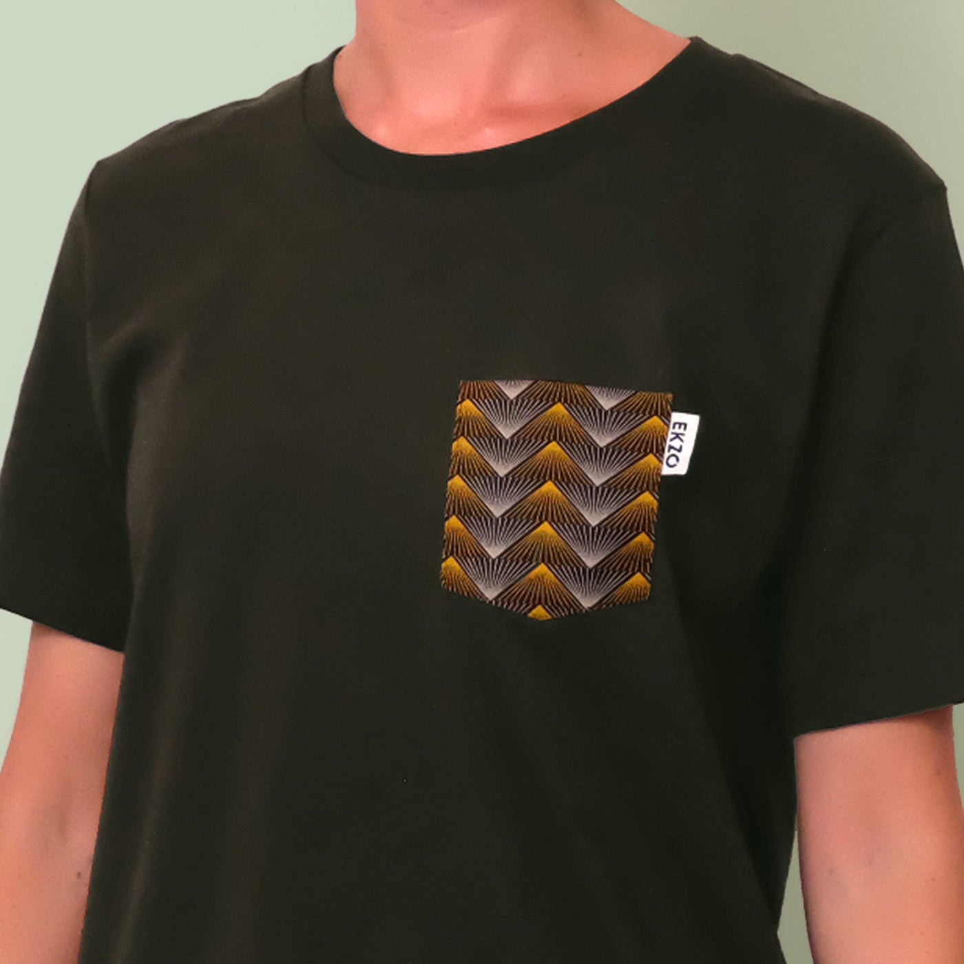 Close up of gold and gray patterned chest pocket on a dark green shirt