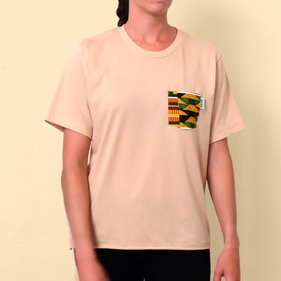 Woman wearing tan t-shirt with African print chest pocket