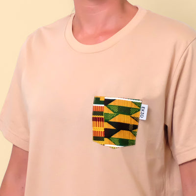 Close-up of African wax fabric chest pocket on tan t-shirt