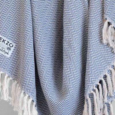 Close up of blue and white woven blanket with white tassels