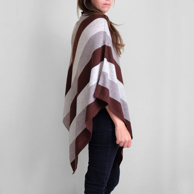 Side view of woman wearing white gray and brown striped poncho