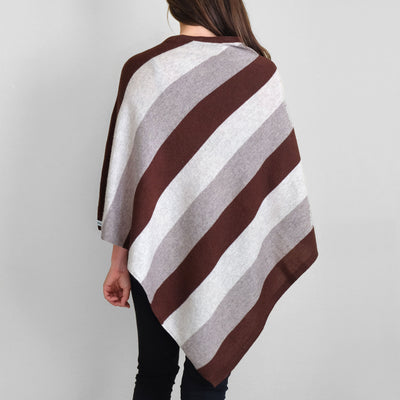 Back view of woman wearing white gray and brown striped poncho