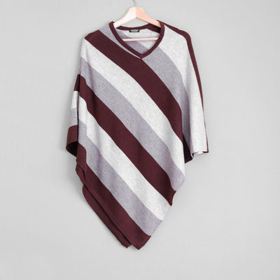 White gray and brown striped poncho hanging on wooden coat hanger